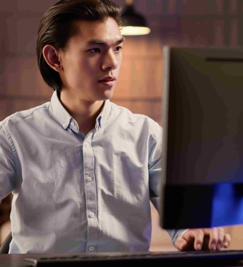 focused-asian-man-working-commercial-report-website-using-computer