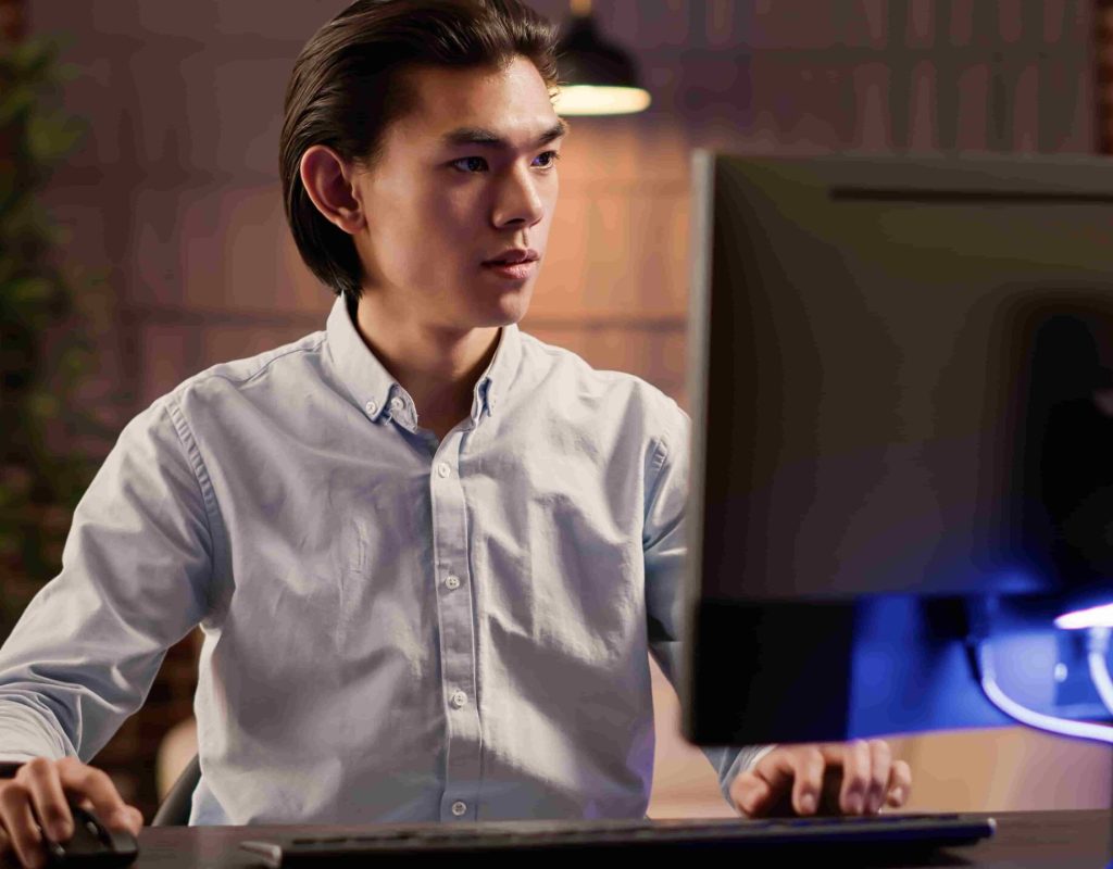 focused-asian-man-working-commercial-report-website-using-computer
